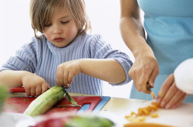 Son (4-7) and mother cutting vegetables, close-up - WESTF00233