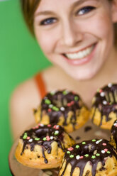 Junge Frau mit Kuchen in der Hand, lächelnd, Nahaufnahme - MFF00186