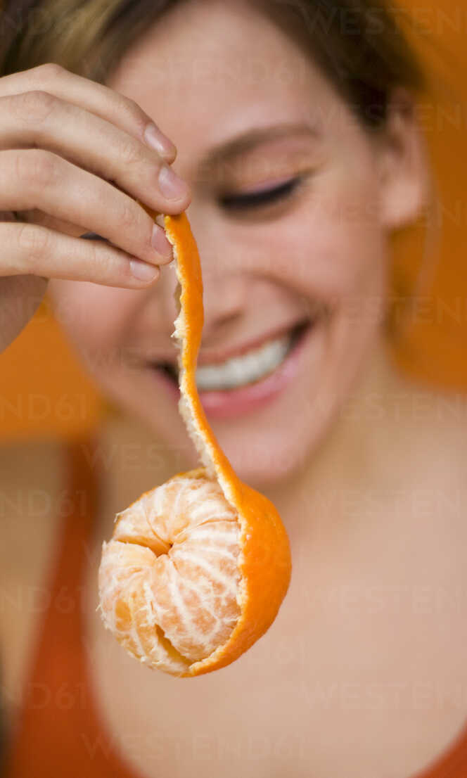 Young Woman holding tangerine, close-up stock photo