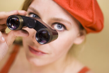Young woman holding binocular, close-up, portrait - MFF00181