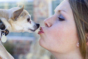 Woman kissing her dog, portrait - MF00200