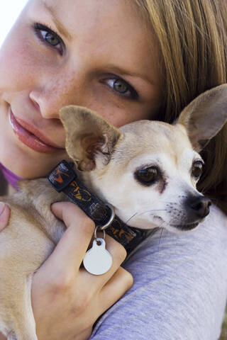 Woman holding her dog, portrait stock photo