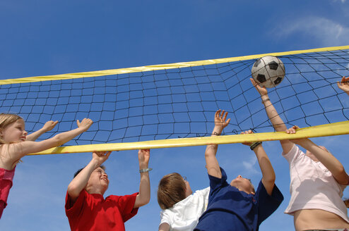 Children (6-9) playing volleyball, low angle view - CRF00874