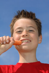 Junge (6-7) isst Karotte, niedrige Ansicht, Nahaufnahme - CRF00868