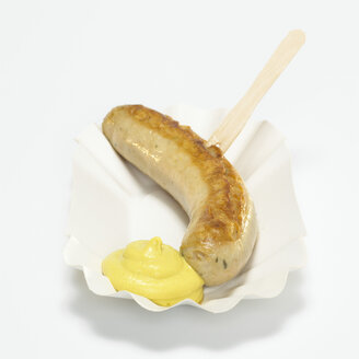 German Bratwurst, fried sausage with mustard in paper plate, close-up - WESTF00384