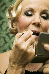 Senior woman painting lips - WEST00352