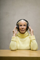 Senior woman wearing headphones, looking up, close-up - WESTF00659