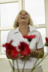 Senior woman laughing, looking up, portrait - WESTF00633