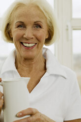 Senior woman holding jug, smiling, close-up, portrait - WESTF00622