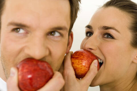Junges Paar isst Apfel, Nahaufnahme, lizenzfreies Stockfoto