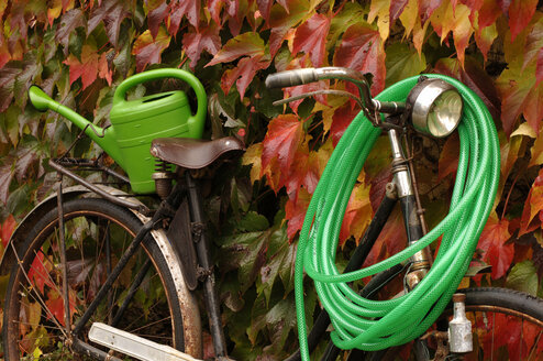 Fahrrad mit Rohr und Gießkanne im Herbst - ASF02087
