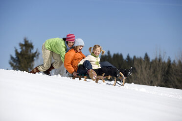 Austria, girls (6-17) with sledge playing in snow, low angle view - WESTF00690