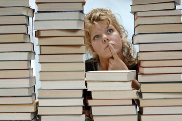 Woman with pile of books, looking up - CRF00906