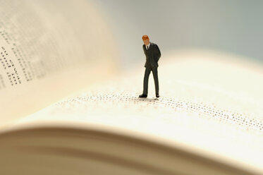 Figurine of businessman kept on open book - ASF02206