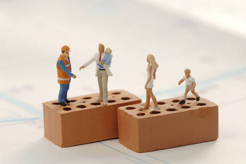 Figurines of construction workers and family at construction site stock photo