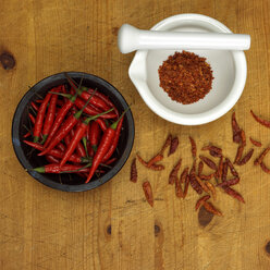 Chili powder in mortar with chillies in bowl, close-up - WESTF00861