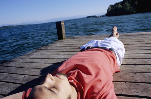 Junger Mann entspannt sich auf dem Bootssteg, Nahaufnahme - WESTF01181