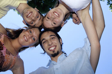 Four young people in huddle, upward view, portrait - WESTF01163