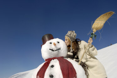 Junge Frau küsst Schneemann, flacher Blickwinkel - WESTF00929