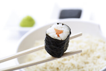 Maki Sushi mit Stäbchen über einer Schüssel mit Reis, Nahaufnahme - 03702CS-U