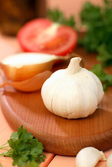 Tomate, Zwiebel, Knoblauch und Petersilie auf dem Schneidebrett in Scheiben schneiden - WESTF01362