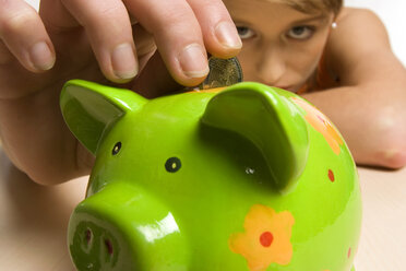 Young woman with green piggy bank, close-up - CLF00103