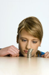 Young woman with pile of coins - CLF00097