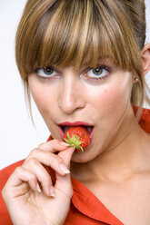 Young woman eating strawberry - WESTF01288