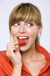 Junge Frau isst Erdbeere, Nahaufnahme - WESTF01287