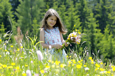 Mädchen (6-7) mit Blumenstrauß auf einer Wiese, lächelnd - WESTF01402