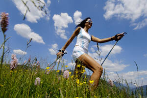 Junge Frau beim Nordic Walking auf einer Wiese, Deutschland, flacher Blickwinkel - WESTF01435