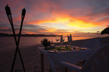 Philippinen, Esstisch am Strand bei Sonnenuntergang - GNF00793