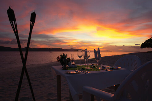 Philippinen, Esstisch am Strand bei Sonnenuntergang - GNF00793