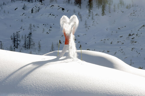 Frau steht auf einem schneebedeckten Berg und wirft Schnee - HHF00501
