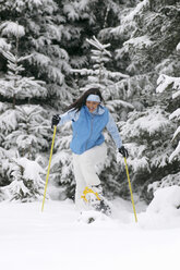 Young woman snowshoeing, laughing - HHF00471