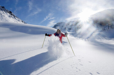 Österreich, Salzburger Land, Junge Frau beim Skifahren in den Bergen, lächelnd - HHF00466