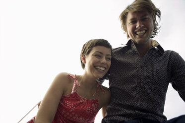 Young couple laughing, portrait, low angle view - WEST01557