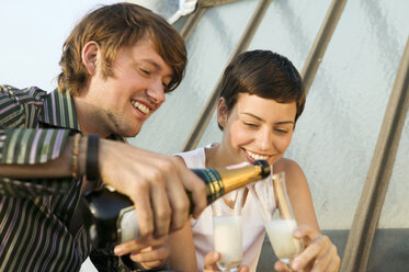 Junges Paar feiert mit Champagner, lächelnd - WEST01536