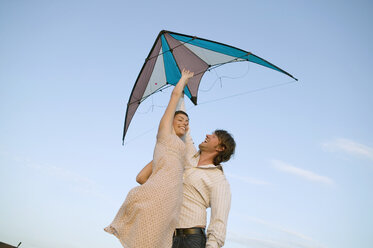Young couple flying kite, low angle view - WEST01513