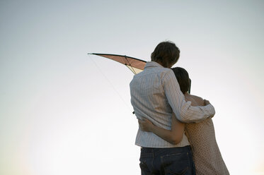 Young couple flying kite, rear view - WEST01512