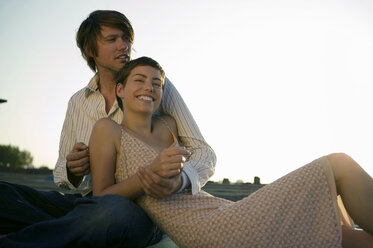 Young couple sitting with sky in background - WEST01494