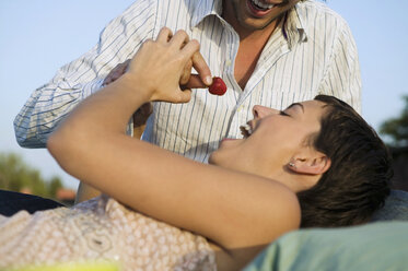 Junger Mann füttert Frau mit Erdbeeren, Nahaufnahme - WEST01489
