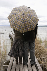 Ehepaar auf Steg mit Regenschirm, Rückansicht - CLF00216