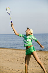 Junge Frau spielt Badminton am Strand - WESTF01841