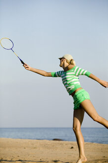 Junge Frau spielt Badminton am Strand - WESTF01840