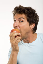 Junger Mann isst Apfel, Porträt, Nahaufnahme - WESTF01661