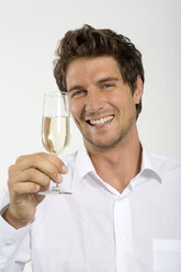 Junger Mann mit einem Glas Champagner in der Hand, Nahaufnahme, Porträt - WESTF01641