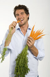 Junger Mann isst Karotten - WESTF01640