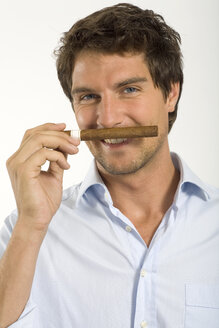 Young man smelling cigar, close-up, portrait - WESTF01638