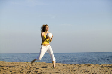 Junge Frau am Strand, die Ball spielt - WESTF01778